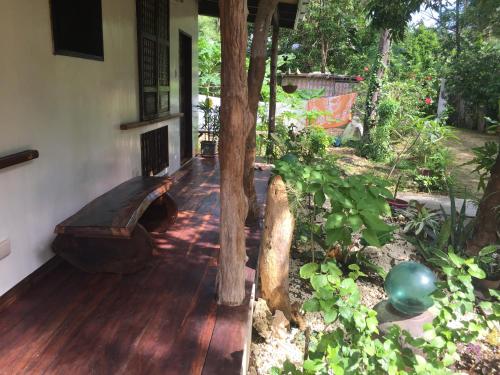 a porch of a house with a tree on it at Rene's Diverslounge Resort in Calape