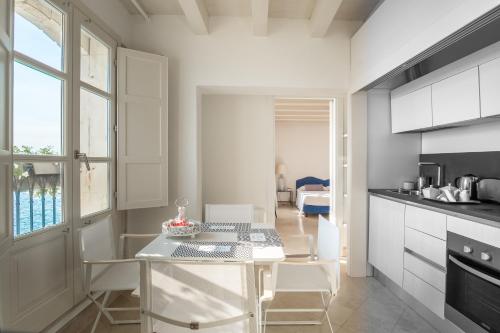 a kitchen with a table and chairs in a room at Palazzo Alfeo Aparthotel in Siracusa