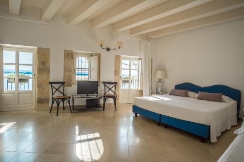 a bedroom with a bed and a television in it at Palazzo Alfeo Aparthotel in Siracusa