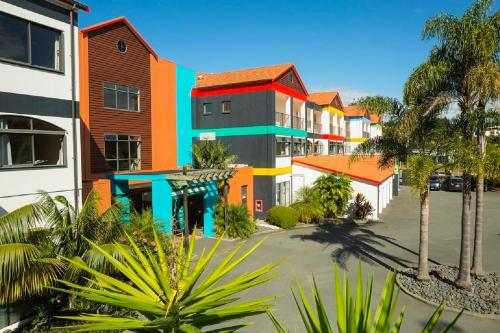 a row of buildings in a street with palm trees at Quality Hotel Oceans Tutukaka in Tutukaka