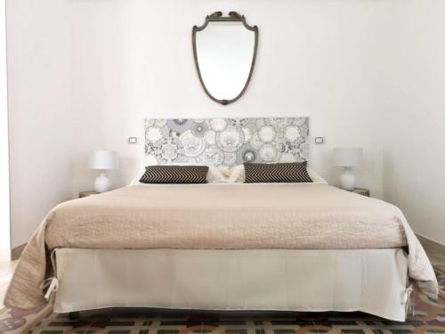 a bedroom with a large bed with a mirror on the wall at Eccelsoleccese Boutique B&B - steps from the Historic Center in Lecce