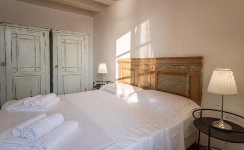 a bedroom with a white bed with two towels at Palazzo Alfeo Aparthotel in Siracusa