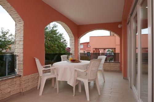 a white table and chairs on a patio at Apartments Adriapag in Pag