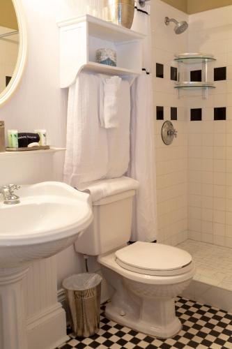 a white bathroom with a toilet and a sink at The Marshall House, Historic Inns of Savannah Collection in Savannah
