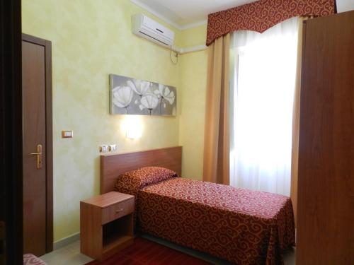 a small bedroom with a bed and a window at Hotel Air Palace Lingotto in Turin