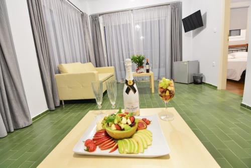 a table with a plate of fruit and a bottle of wine at Marzi Boutique Hotel in Nerátza