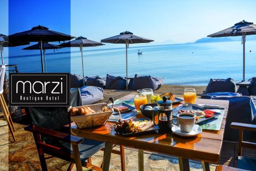 a table with food and a view of the ocean at Marzi Boutique Hotel in Nerátza