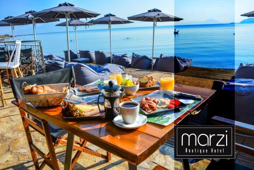 a table with food on it with a view of the ocean at Marzi Boutique Hotel in Nerátza