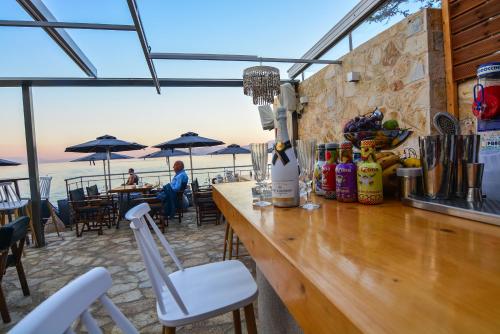 a bar in a restaurant with a view of the ocean at Marzi Boutique Hotel in Nerátza