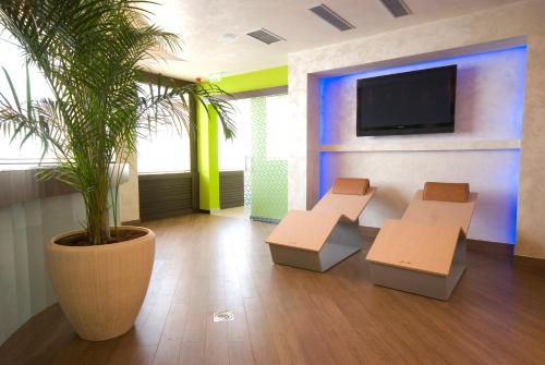 a waiting room with two chairs and a potted plant at Garni Hotel Aleksandar in Novi Sad