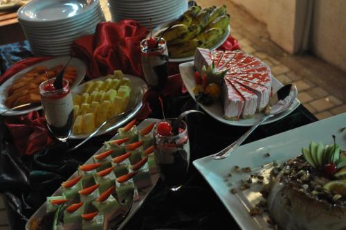 a table topped with plates of food and desserts at Amaara Sky Hotel Kandy in Kandy