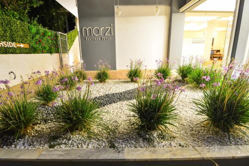 a flower garden in front of a store at Marzi Boutique Hotel in Nerátza