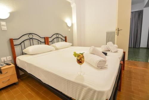 a bedroom with two beds with towels and a vase at Marzi Boutique Hotel in Nerátza