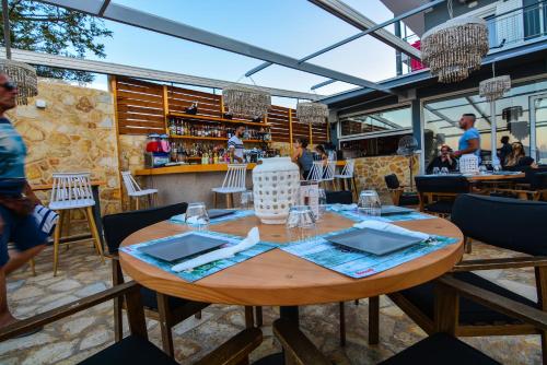 a restaurant with a wooden table and a bar at Marzi Boutique Hotel in Nerátza
