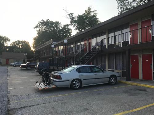 a car parked in a parking lot in front of a building at Budget Host Village Inn in Kirksville