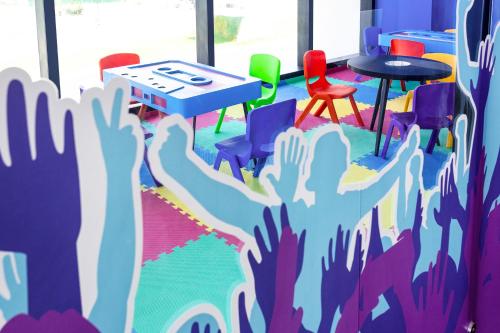 a room with a table and chairs with their hands up at Ibis Styles Merida Galerias in Mérida
