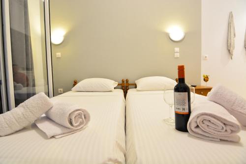 two beds with towels and a bottle of wine at Marzi Boutique Hotel in Nerátza