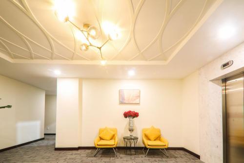 a lobby with two yellow chairs and a table with flowers at Lake View Hotel in Quy Nhon