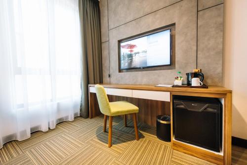 a room with a desk with a chair and a television at The Smith House in Pantai Cenang