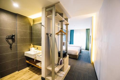 a hotel room with a bathroom with a bed and a sink at The Smith House in Pantai Cenang