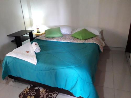 a blue bed with green pillows in a room at Vivienda Turistica Yerbabuena in Filandia