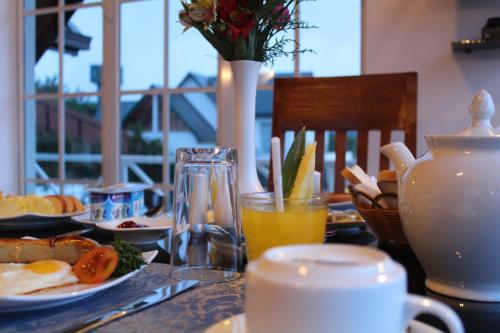 een tafel met borden met voedsel en sinaasappelsap bij Dewdrops at Lake Gregory in Nuwara Eliya