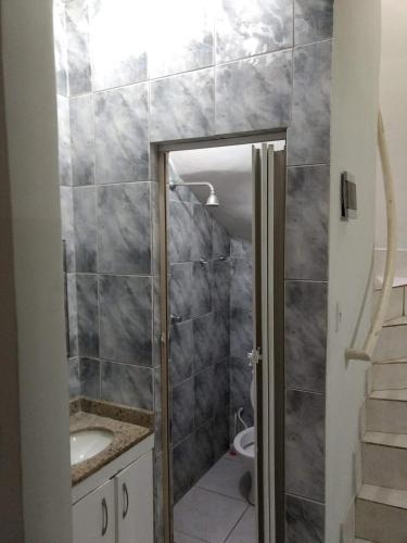 a bathroom with a shower and a sink and a toilet at Edificio Netuno in Cabo Frio