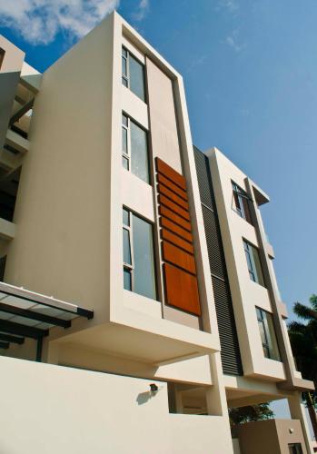 a white building with a wooden door on it at Avya's Studio 113 at Ebene Square, Ebene in Ebene