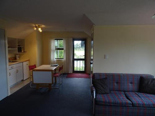 a living room with a blue couch and a table at Alpine Chalets in National Park