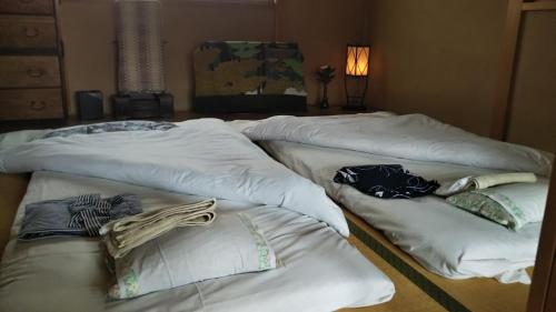a group of three beds sitting in a room at Kyoto Narutaki Keisenso in Kyoto
