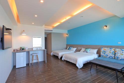 a hotel room with two beds and a blue wall at Two Home Inn in Hualien City