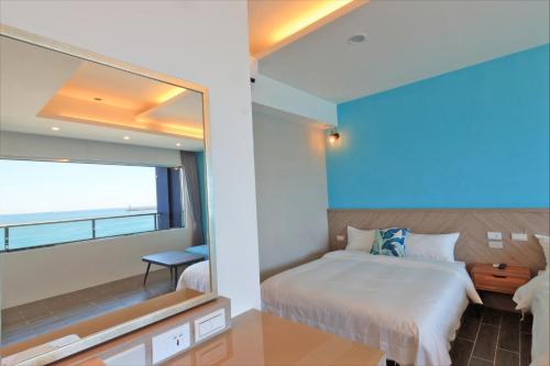 a bedroom with a bed and a large window at Two Home Inn in Hualien City