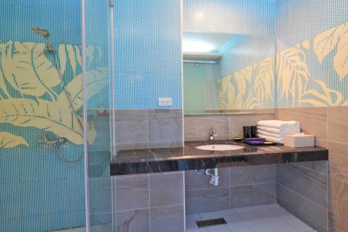a bathroom with a sink and a shower with a mirror at Two Home Inn in Hualien City