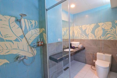 a bathroom with a shower and a toilet at Two Home Inn in Hualien City