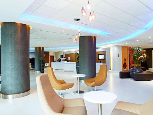 a lobby with chairs and tables and columns at Novotel London Waterloo in London