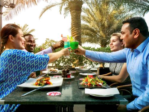 a group of people sitting at a table drinking drinks at Novotel Abu Dhabi Gate in Abu Dhabi