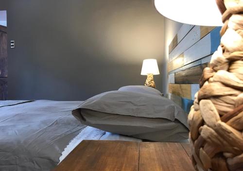 a bedroom with a bed with a table and a lamp at Hotel El Milagro in Pisco Elqui