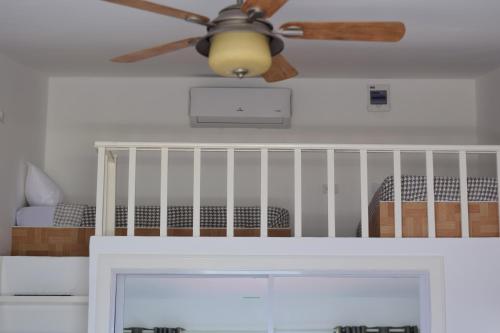 a ceiling fan in a bedroom with a crib at the beachhouse in Dalaguete