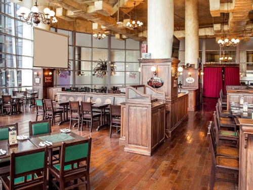 a restaurant with tables and chairs and a bar at Novotel Abu Dhabi Gate in Abu Dhabi