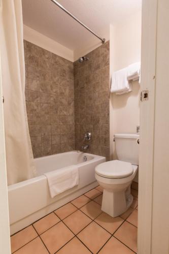 a bathroom with a toilet and a tub and a sink at Grandview Motel in Kamloops