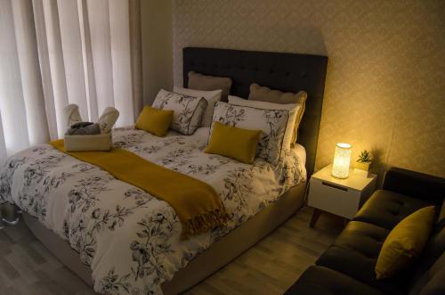 Un dormitorio con una cama con almohadas amarillas y blancas. en Aya Luxury Apartments 56, en Durban