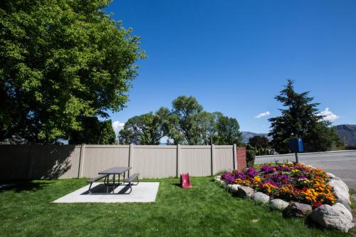 a park with a bench and flowers in a yard at Grandview Motel in Kamloops