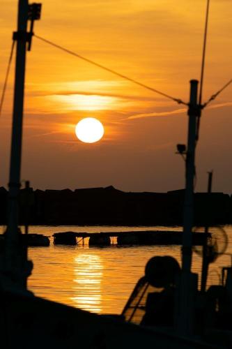 a sunset over a body of water with the sun at Guest House Itokawa in Matsuzaki