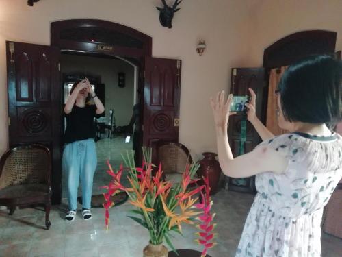 a woman taking a picture of herself in a mirror at Old Parkland Hostel in Galle