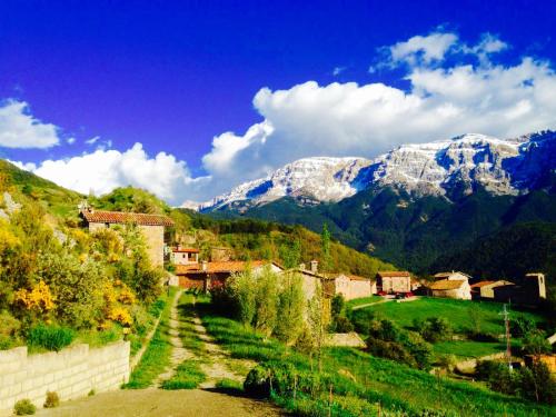 un pueblo en una colina con montañas nevadas en el fondo en Cal Baridà, en Cava