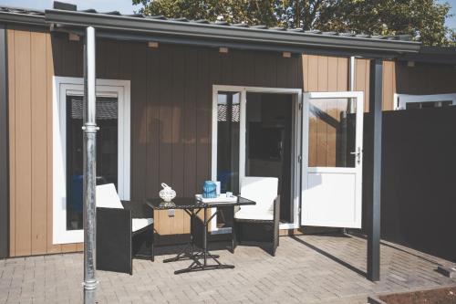 a patio with a table and chairs next to a building at Lodgepark Goitzsche GmbH in Große Mühle