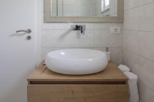 a bathroom with a white sink and a mirror at Apartman Nada in Sinj