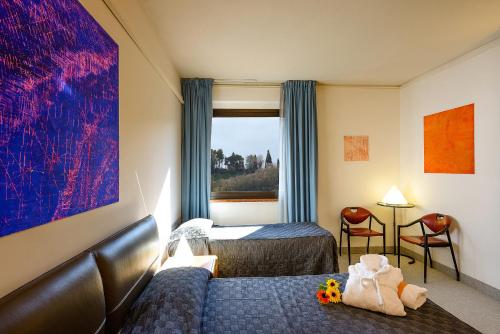 a hotel room with a bed and a window at Albornoz Palace Hotel in Spoleto