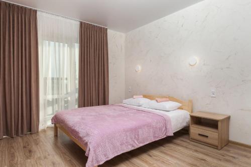 a bedroom with a bed with a pink blanket and a window at Villa "White Pearl" Zatoka in Zatoka