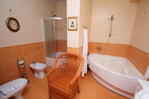 a bathroom with a tub and a toilet and a sink at Medzhybozhskiy Zamok in Tribukhovtsy